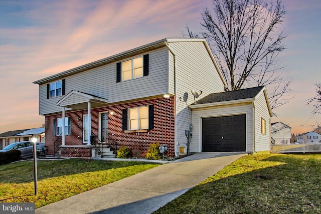 colonial-style house featuring brick siding, an attached garage, concrete driveway, and a front lawn