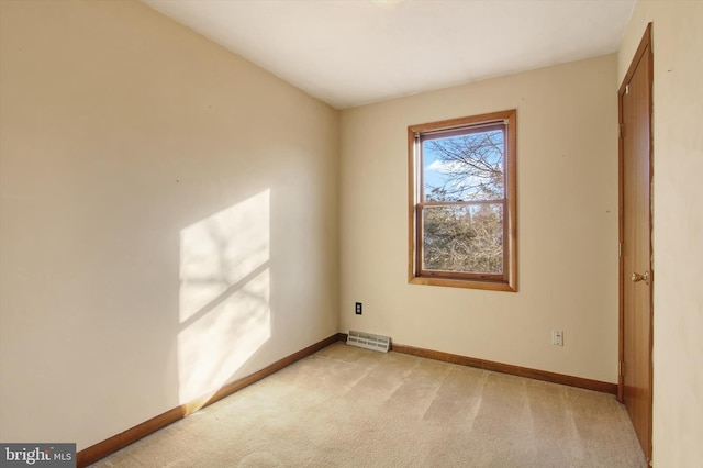 interior space featuring baseboards, visible vents, and light carpet