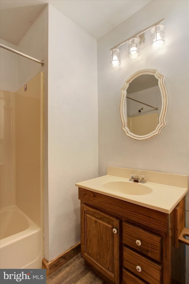 bathroom with shower / washtub combination, vanity, and wood finished floors