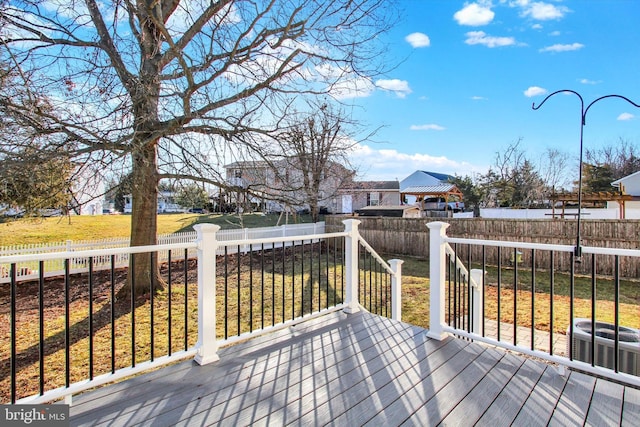 deck with a fenced backyard, a lawn, and central AC