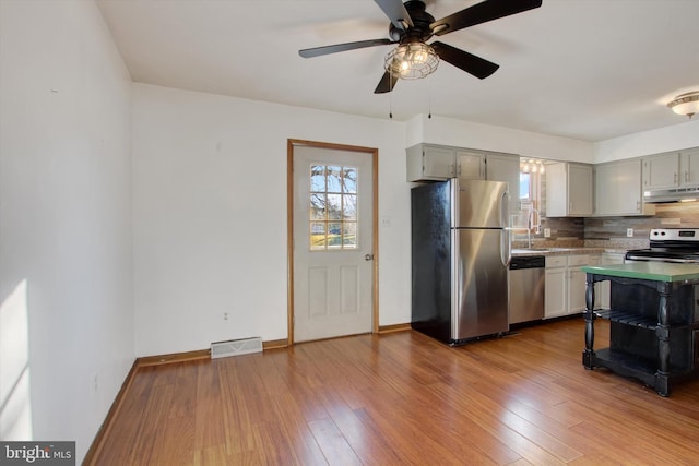 kitchen featuring wood-type flooring, visible vents, under cabinet range hood, and stainless steel appliances