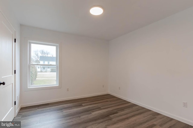 spare room featuring baseboards and wood finished floors