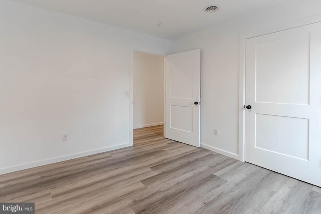 unfurnished bedroom with visible vents, baseboards, and light wood finished floors