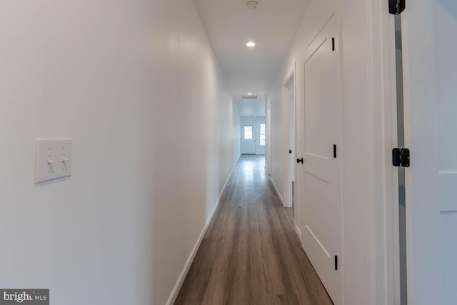 corridor featuring dark wood-type flooring, recessed lighting, and baseboards