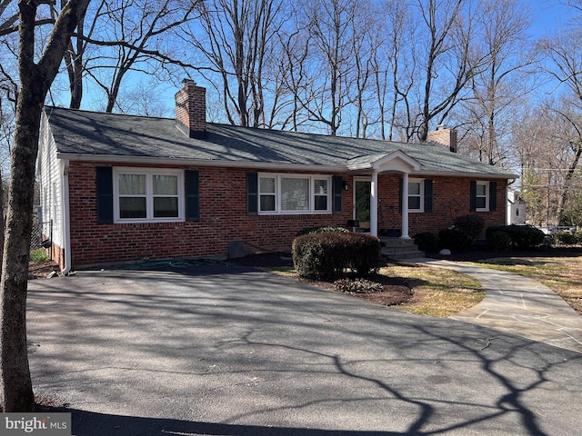 ranch-style home with brick siding and a chimney