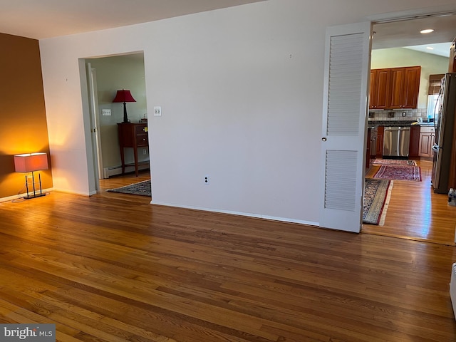 interior space with dark wood finished floors, baseboards, visible vents, and baseboard heating