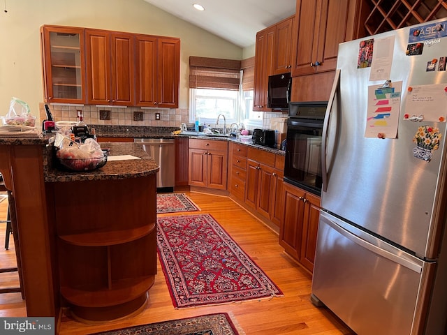 kitchen with open shelves, a sink, black appliances, vaulted ceiling, and light wood-style floors