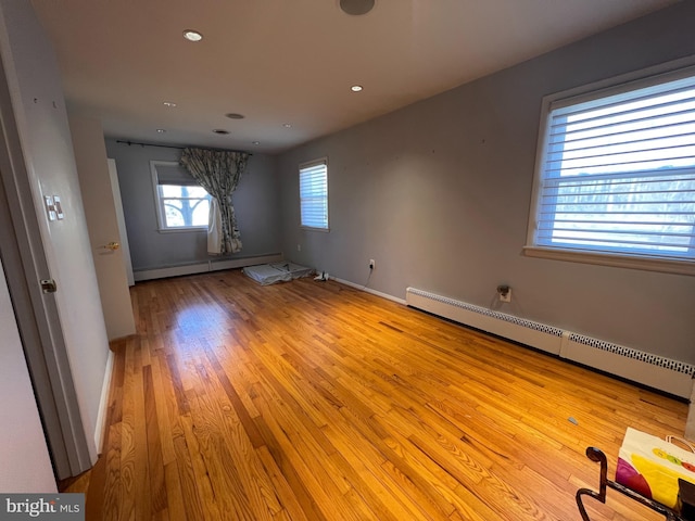 unfurnished room with recessed lighting, a baseboard radiator, baseboards, and light wood-style flooring