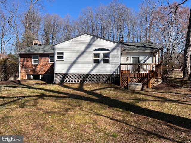 view of home's exterior with a wooden deck, a chimney, and a yard