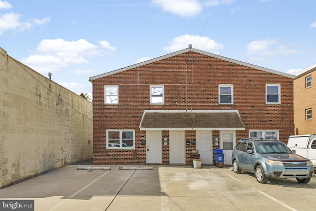 view of front of property with brick siding and fence