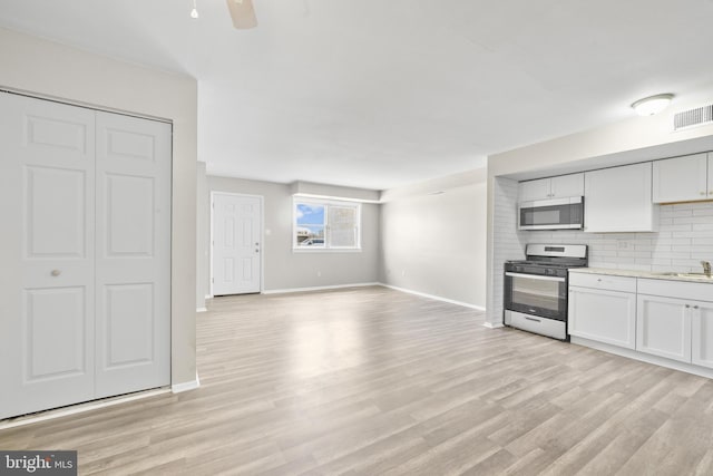 kitchen with tasteful backsplash, visible vents, stainless steel appliances, and light wood-style floors