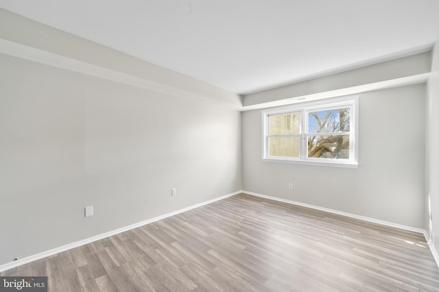 empty room featuring baseboards and wood finished floors