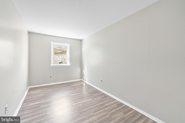 empty room featuring baseboards and light wood-style floors