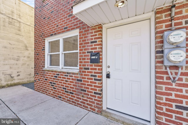 doorway to property with brick siding