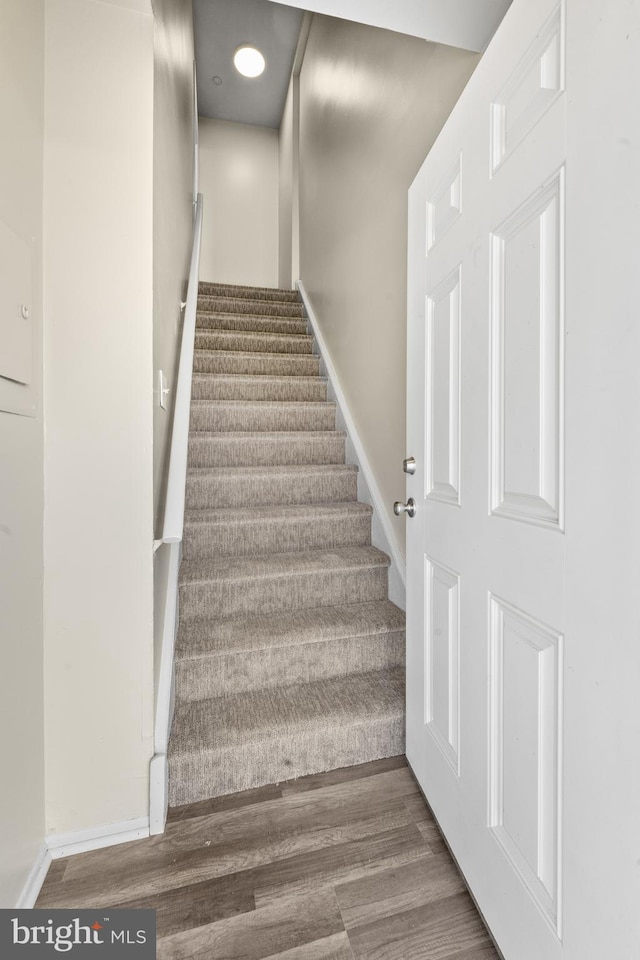 stairway with baseboards and wood finished floors