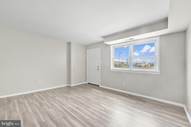 empty room with visible vents, baseboards, and light wood-type flooring