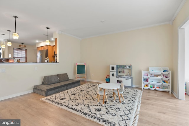 living room featuring baseboards, light wood-style floors, and ornamental molding