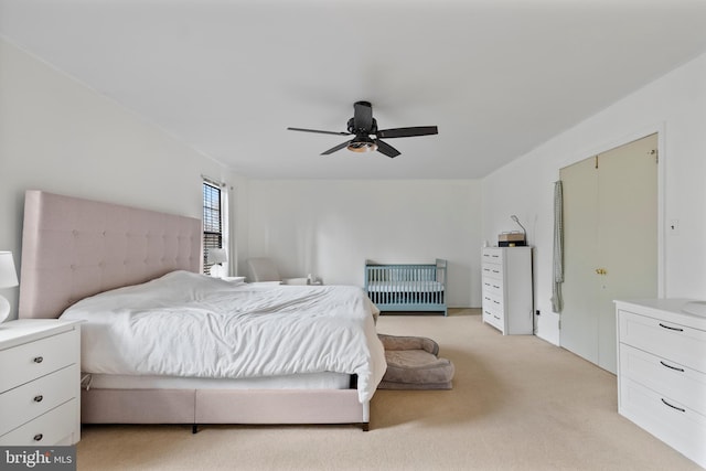 bedroom with light colored carpet and a ceiling fan