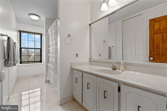 bathroom with vanity, tile patterned floors, and baseboards