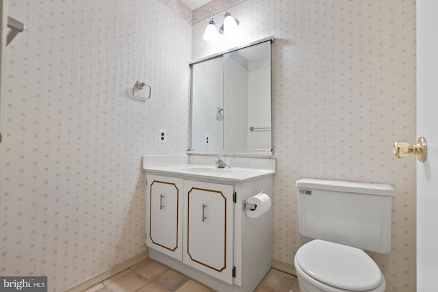 bathroom with wallpapered walls, toilet, vanity, and tile patterned flooring