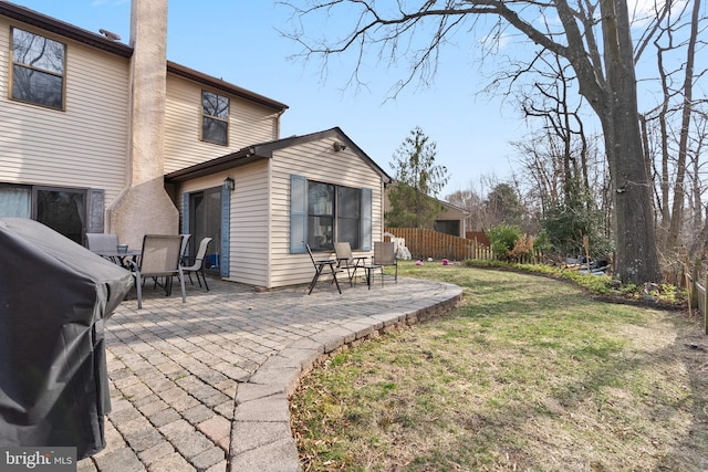 rear view of property with a yard, a patio, and fence