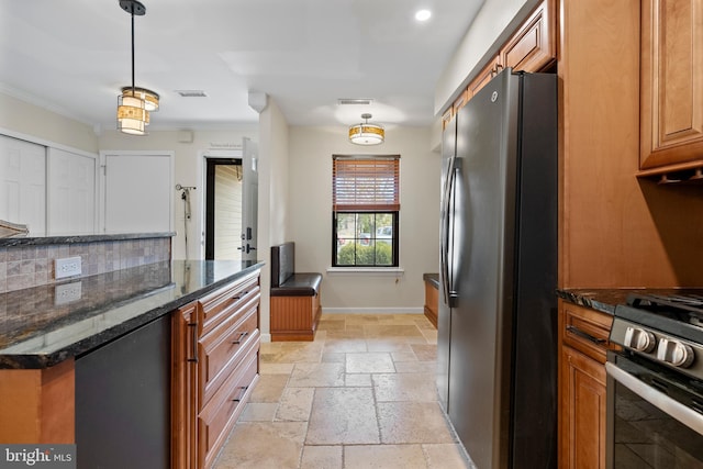 kitchen with visible vents, baseboards, stainless steel range with gas stovetop, stone tile floors, and freestanding refrigerator