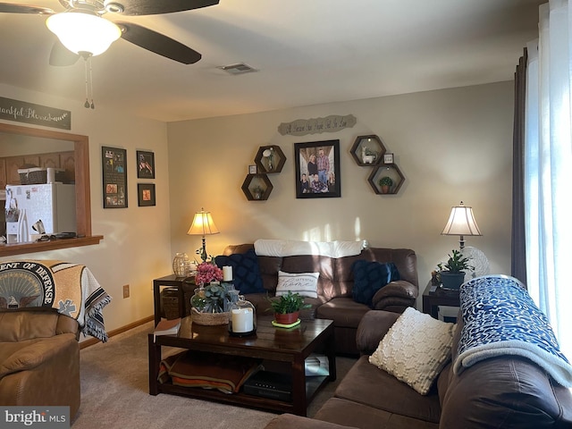 carpeted living area featuring visible vents, baseboards, and ceiling fan