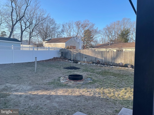 view of yard with an outdoor fire pit and a fenced backyard