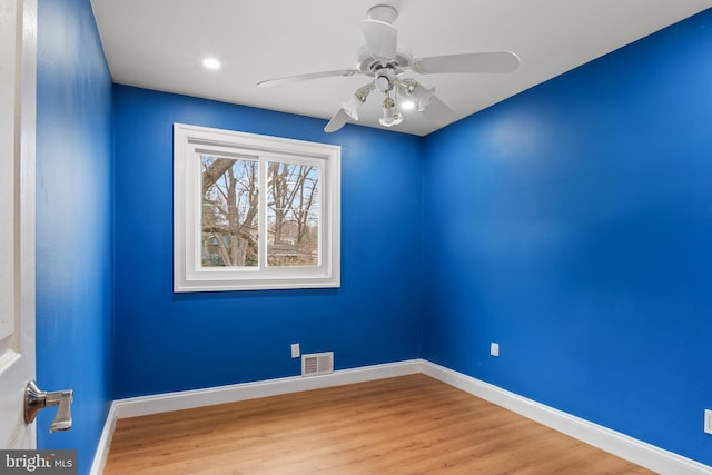 empty room with visible vents, baseboards, wood finished floors, and a ceiling fan