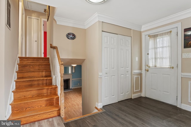 entryway featuring baseboards, stairs, crown molding, and dark wood-type flooring