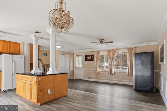 kitchen with ornamental molding, a ceiling fan, dark countertops, freestanding refrigerator, and decorative columns