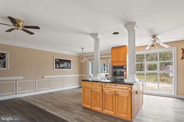 kitchen with ceiling fan, ornamental molding, decorative columns, and oven