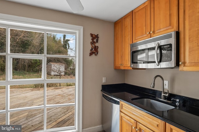 kitchen featuring brown cabinetry, appliances with stainless steel finishes, and a sink