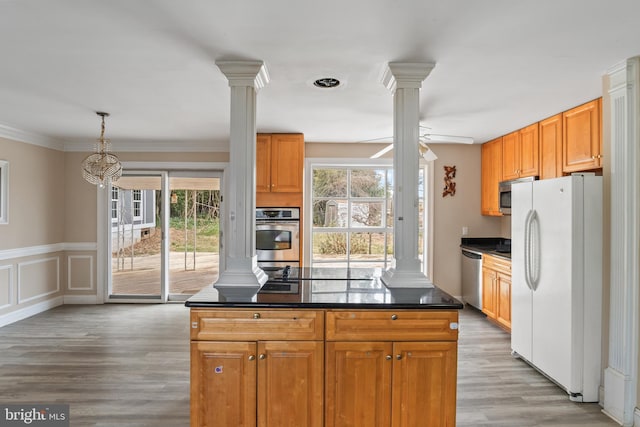 kitchen featuring dark countertops, ceiling fan, light wood-style flooring, appliances with stainless steel finishes, and ornate columns