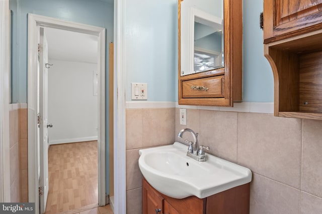 bathroom with tile walls, wainscoting, and vanity