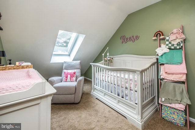 bedroom with lofted ceiling with skylight, a nursery area, and carpet floors