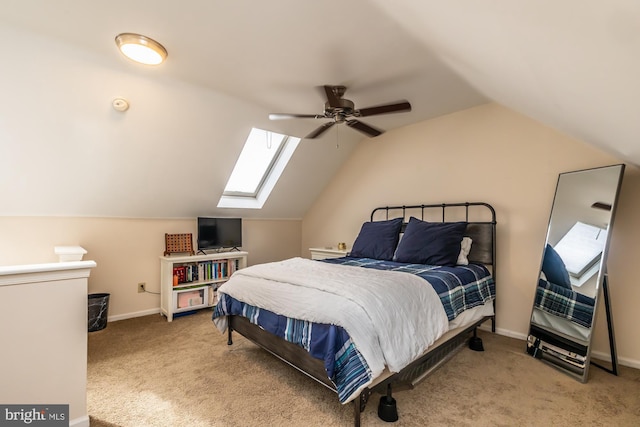 carpeted bedroom featuring baseboards and vaulted ceiling with skylight