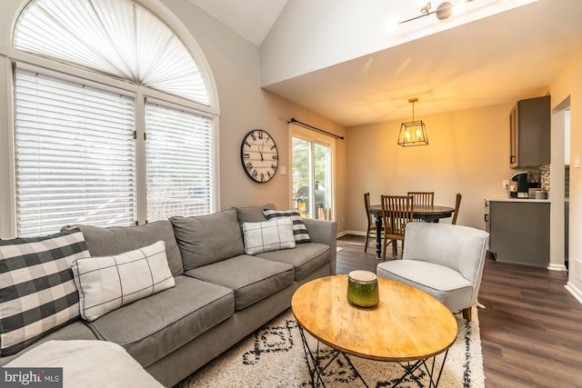 living room with baseboards, dark wood finished floors, and vaulted ceiling