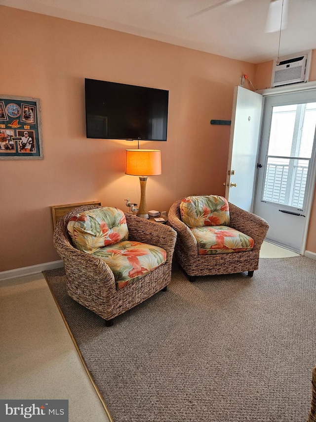 living area with an AC wall unit and baseboards