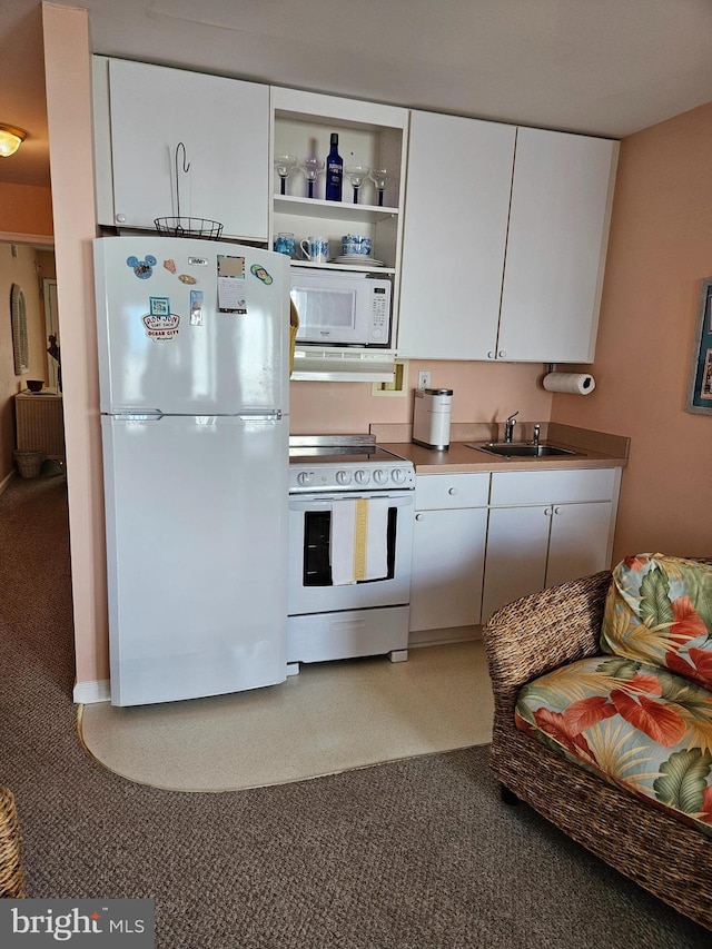 kitchen featuring white appliances, white cabinetry, and a sink