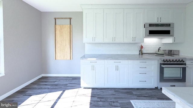 kitchen featuring dark wood finished floors, high end range, tasteful backsplash, and light countertops