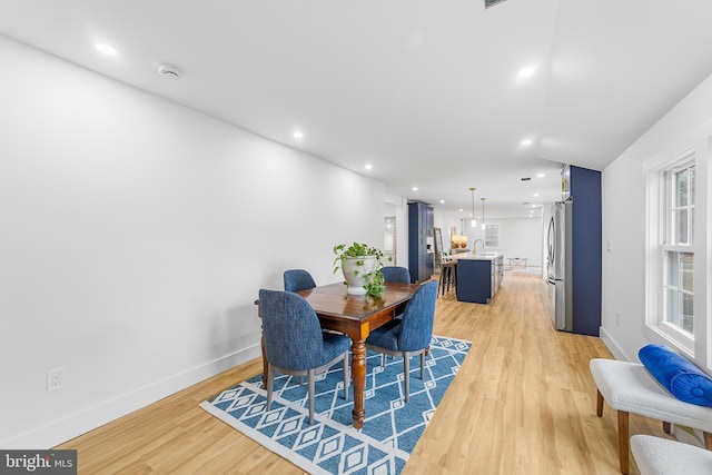 dining space with light wood finished floors, recessed lighting, and baseboards