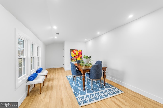 dining room with vaulted ceiling, baseboards, and wood finished floors