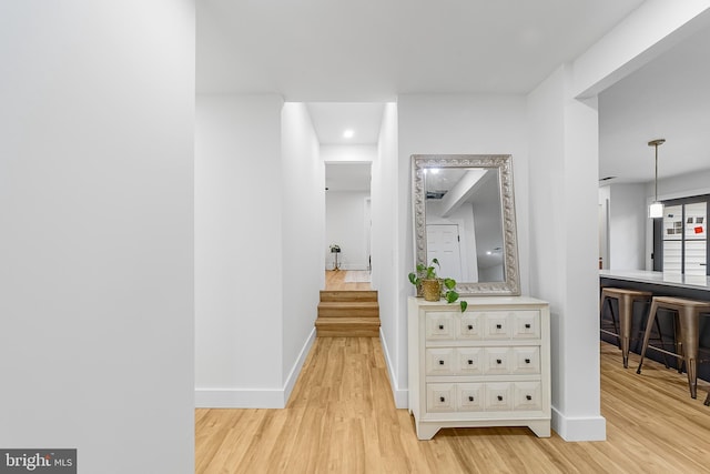 hall featuring baseboards and light wood-style flooring