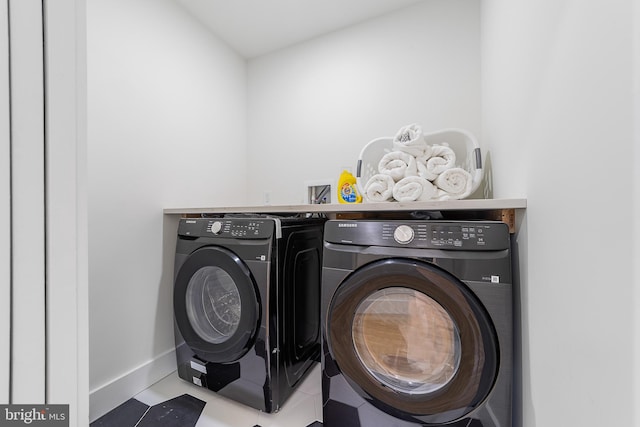 clothes washing area with tile patterned flooring, laundry area, baseboards, and independent washer and dryer