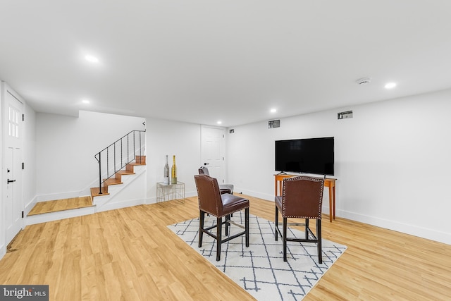 living room with stairs, recessed lighting, wood finished floors, and baseboards