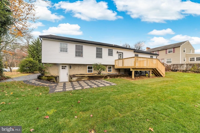 rear view of property with a yard, a deck, stairs, and fence