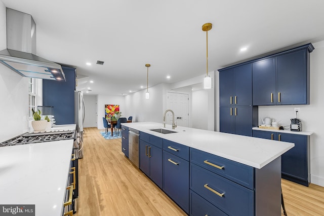 kitchen featuring blue cabinetry, light countertops, light wood-style floors, exhaust hood, and a sink