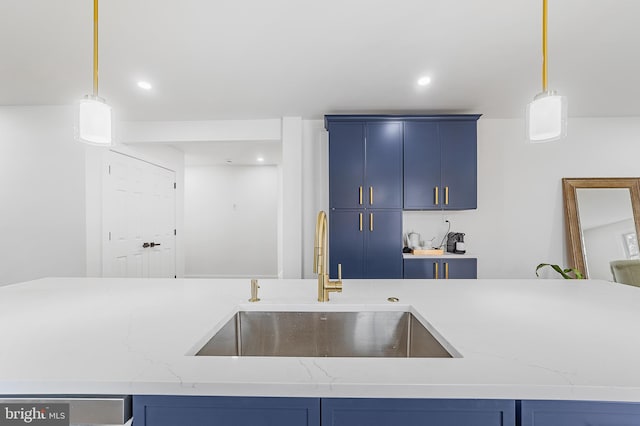 kitchen with blue cabinetry, decorative light fixtures, and a sink