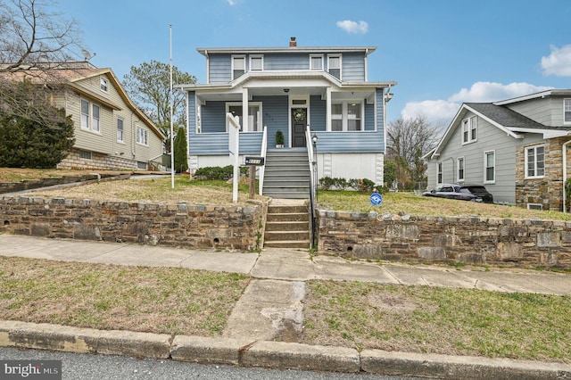 view of front of home with stairway, covered porch, and a chimney